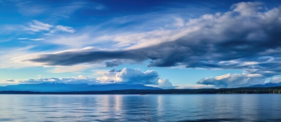 Obraz premium Scenic view of a peaceful lake with a majestic mountain in the background