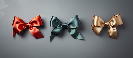 Three distinct bows in different colors neatly lined up on a plain gray surface