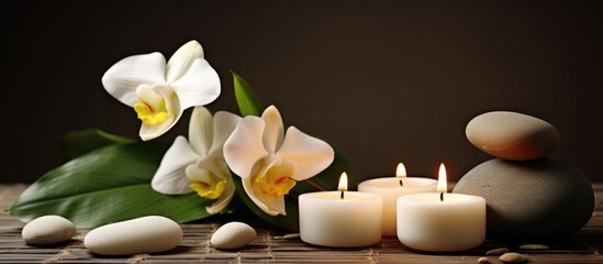 Orchids, candles, and stones arranged on a bamboo mat for a serene ambiance