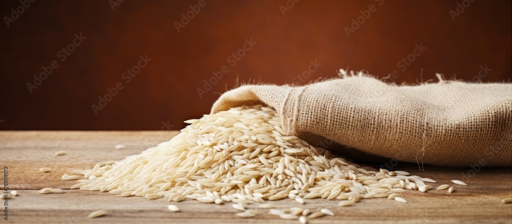 Wall mural Sack of rice seen up close sitting on a rustic wooden table