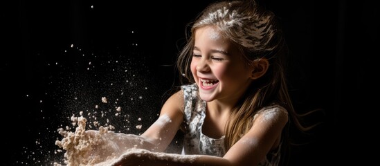 Young girl in a white dress joyfully engaging with a bowl of flour, creating a playful mess