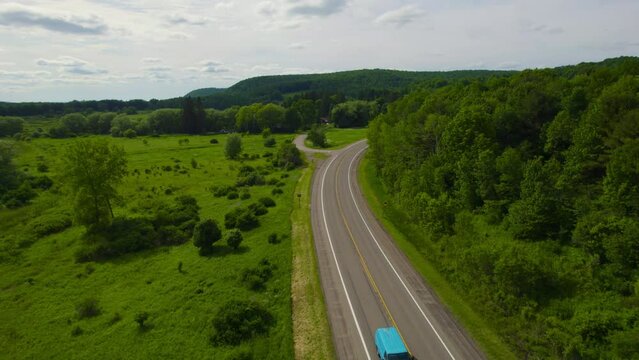 Flying over the country road during the middle of summer.