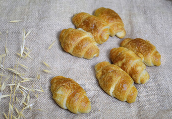 Small croissants on organic fabric in a natural beige color