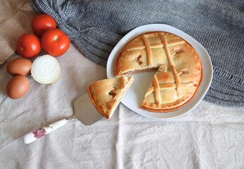 Freshly baked round tuna pie on beige background