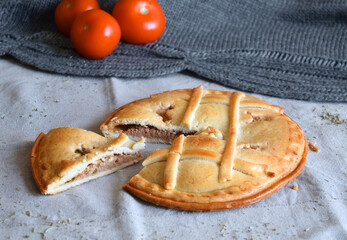 Freshly baked round tuna pie whit red tomatoes  