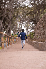 Fototapeta na wymiar Child running free and happy in a park in Lima peru