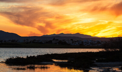 Vibrant sunset over salt lake in Cyprus Larnaca in spring with orange sky and clouds