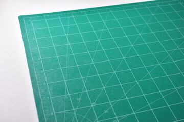 green cutting mat board on white background with line and scale measure guide pattern for object art design, tool equipment of diy craft work
