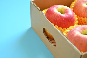 beautiful pink apple in the box on blue background - 781031473
