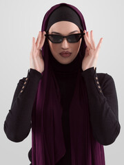 Portrait of beautiful stylish young muslim woman wearing black hijab and sunglasses as modern eastern fashion concept posing on white background. - 781032201
