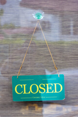 Behind the glass door hangs a sign that says Closed