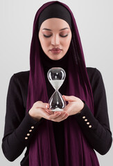 Beautiful arab businesswoman wearing hijab and holding sand clock. Time is passing and it's a pressure concept. - 781033005