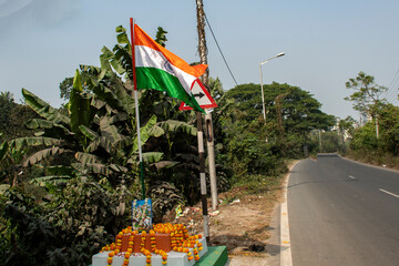Indian tri color flag flying high on a road side pole.