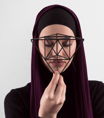 Muslim woman wearing modern stylish wear and hijab isolated on grey background. Diverse people model hijab fashion concept. Face recognition and biometric data identify face science.
