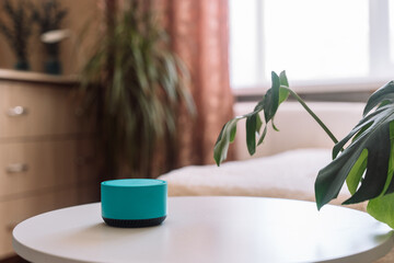 Blue wireless smart speaker on white table in room.