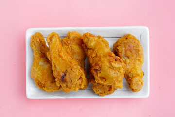 Fried chicken on pink background.