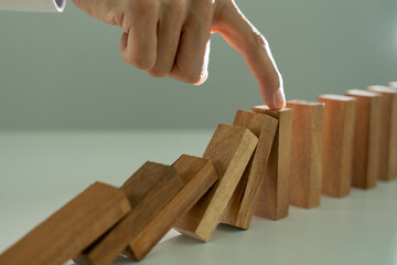 insurance with hands protect domino. Businessman hands stop dominoes falling in business crisis....