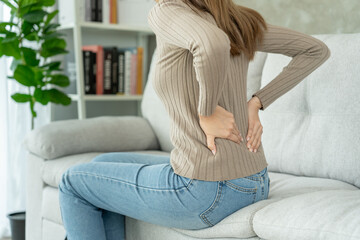 woman holding her lower back while and suffer from unbearable pain health and problems, chronic...
