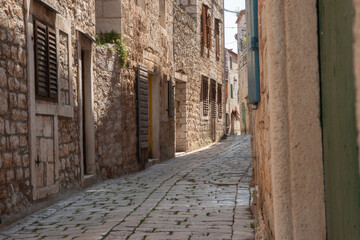 Narrow alleyway between buildings in residential district on Hvar - obrazy, fototapety, plakaty