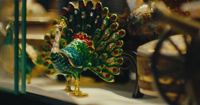 Miniature Cannon And Mini Peacock Figurine In Antique Store - Rack Focus