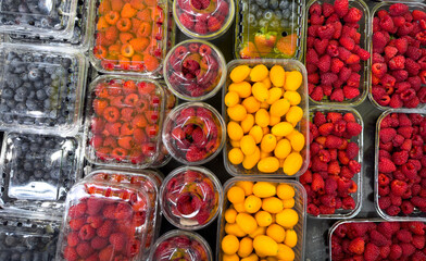 Fresh raspberries and lemons on a counter in a market