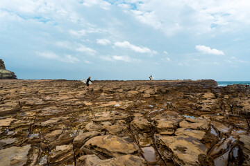Surfers at Avoca beach rock platform, NSW AUSTRALIA