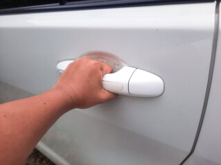 Man hand holding car door handle. Opening the vehicle door with left hand
