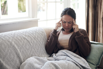 Sick woman, tissue and headache with sinus, flu or pain from illness on living room sofa at home. Tired female person with migraine from high fever, influenza or infection on lounge couch at house