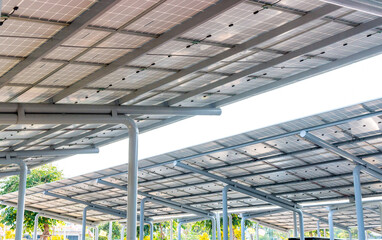 Aerial view of solar panels installed as shade canopy over parking lot with parked cars to generate electricity, photovoltaic technology.