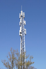 Mast with antennas for mobile telecommunication in the Dutch village of Bergen in spring. Netherlands, April. Blue sky.