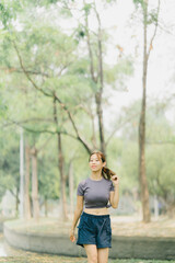 Asian woman stretching and warming up before going for a run at the park. Yoga, health care, weight loss exercise.