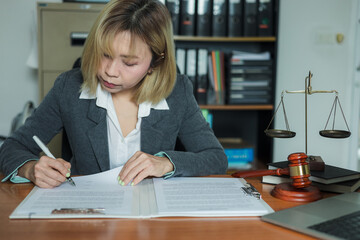 female lawyer at workplace with documents and laptop in office