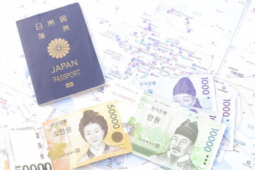 Obraz premium 日本のパスポート（一般旅券5年用紺色）と、韓国の通貨ウォンKRWの紙幣を用意して、韓国旅行の計画を立てる 
