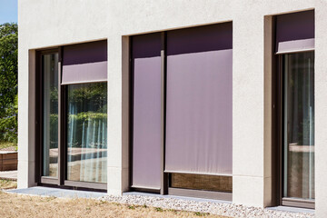 Window Blinds or Shutters Outside. Modern Roller Blind on Large Windows of Modern Facade Building....