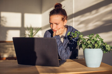 Stressed young woman sitting in front of laptop
