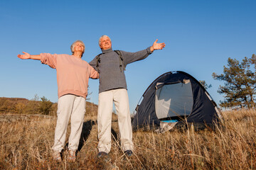 Camping tent vacation Srnior couple man and woman enjoying freedom at forest