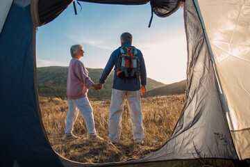 Camping tent vacation Senior couple man and woman sitting near camp tent. - 781103035