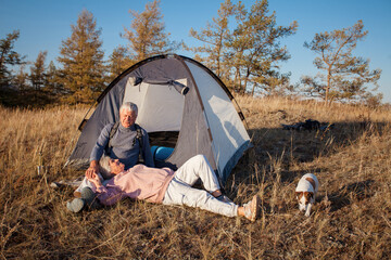 Camping tent vacation Senior couple man and woman sitting near camp tent. - 781103042