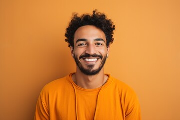 Fototapeta na wymiar A man with a beard and a smile is wearing an orange shirt