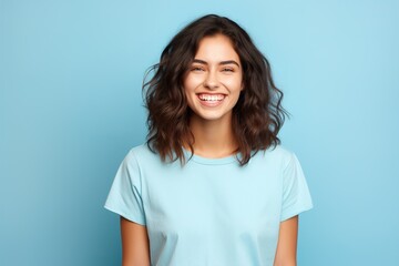 Fototapeta premium A woman with short hair is smiling and wearing a blue shirt