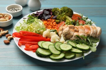 Balanced diet and healthy foods. Plate with different delicious products on light blue wooden table