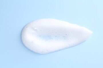 Sample of fluffy foam on light blue background, top view