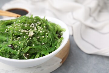 Tasty seaweed salad in bowl on gray table, closeup
