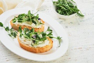 Toast or sandwich with cream cheese and micro greens peas and sunflower. Concept healthy food or snack. Flat lay, copy space.