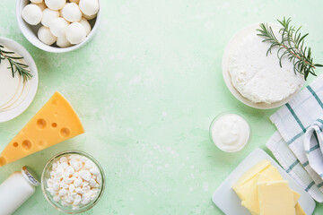 Dairy products or farm products. Fresh organic dairy products milk, cottage cheese, butter, cream, yogurt, sour cream and mozzarella on a light green slate, stone or concrete background. Top view. - obrazy, fototapety, plakaty
