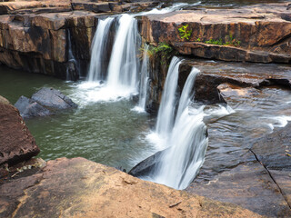 Cool waterfall flowing in the deep forest, shady atmosphere.