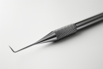 High-contrast image of a stainless steel dental tool with pinpoint focus