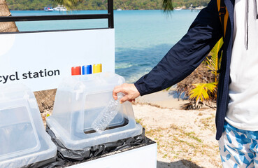  Man hand putting  bottle of a plastic reuse for recycling concept environmental protection world recycle on the sea beach