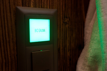 An illuminated sign reading BIO SAUNA in bright green on a dark background at a wellness facility....