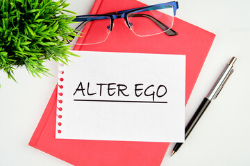 Text Alter ego is translated from Latin as the second self. a real or invented alternative personality of a person. Written on a piece of paper on a red notebook on a white background